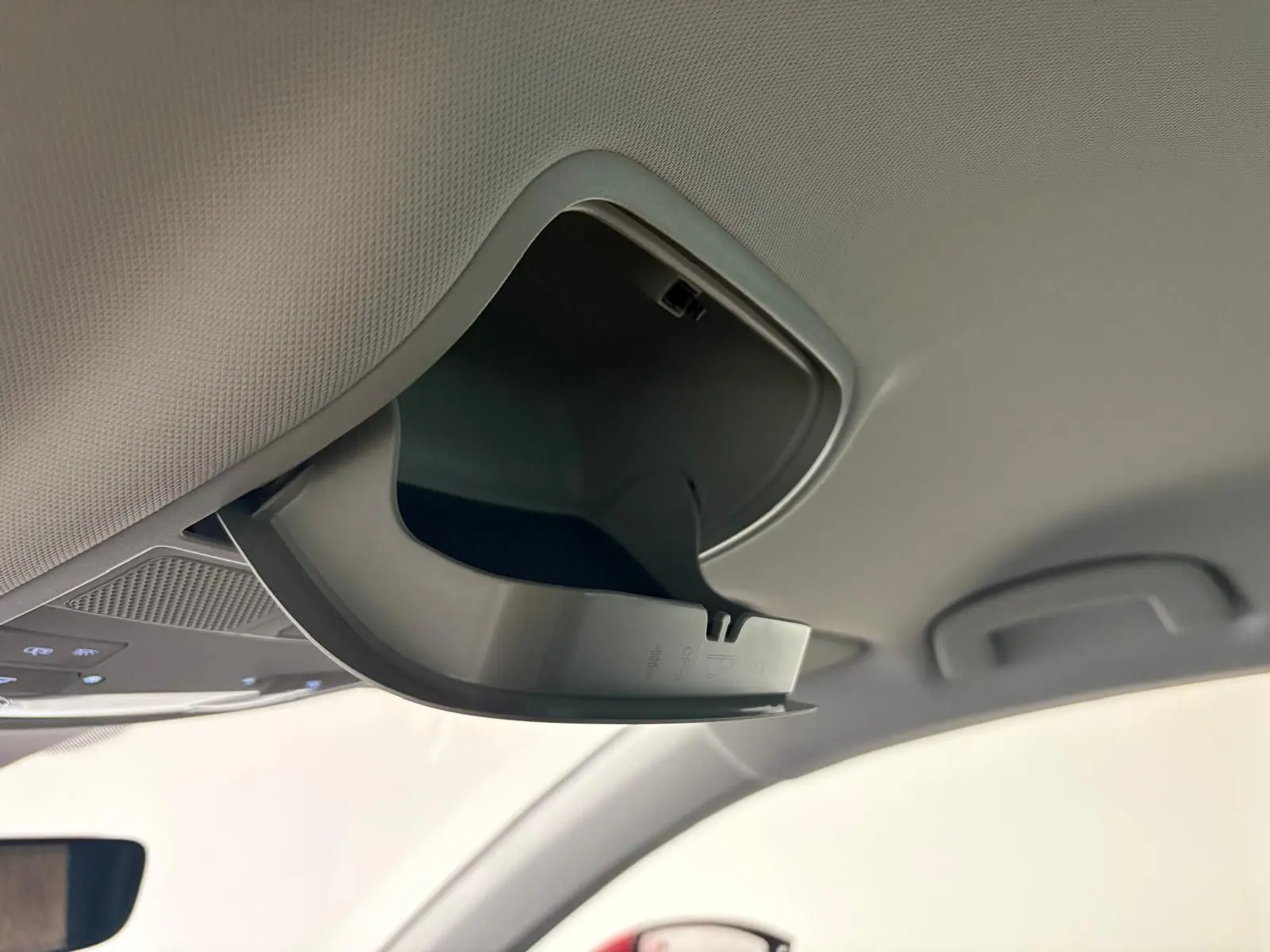 Détail du rangement plafond ouvert dans l'habitacle du SEAT Ateca Rouge Velvet 2024, vue intérieure côté conducteur.