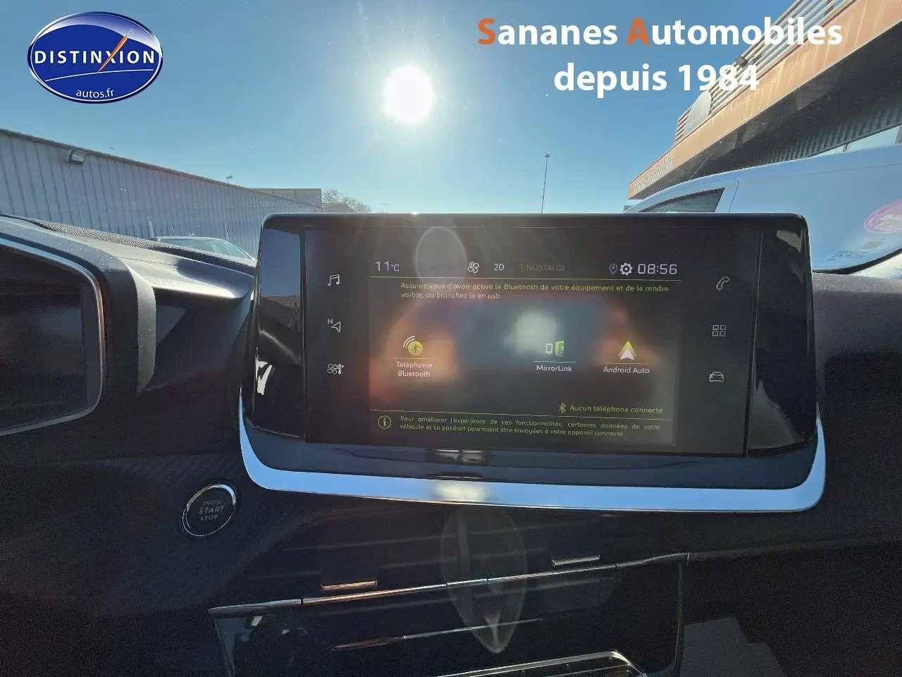 Vue intérieure du tableau de bord du Peugeot 2008 blanc de 2020, avec écran tactile central et bouton démarrage visible.