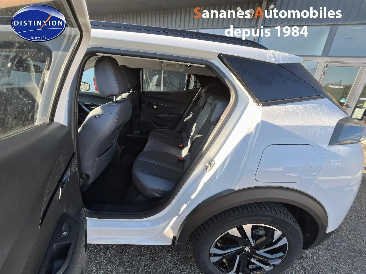 Vue côté droit arrière d’un Peugeot 2008 blanc 2020 avec porte arrière ouverte et sellerie noire visible.