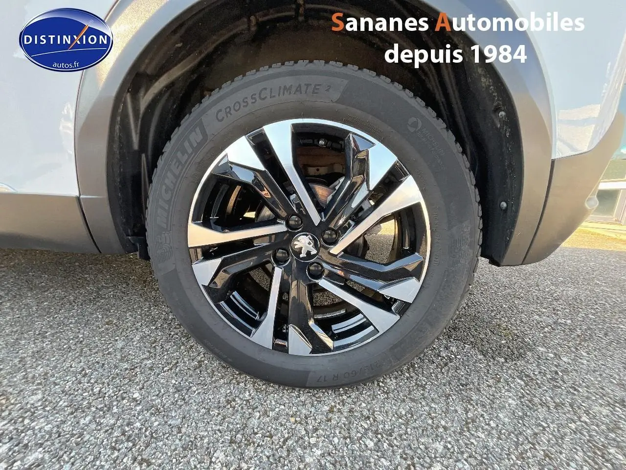 Gros plan sur la jante alliage 17'' bi-ton noir et argent du côté arrière droit d'un Peugeot 2008 blanc.