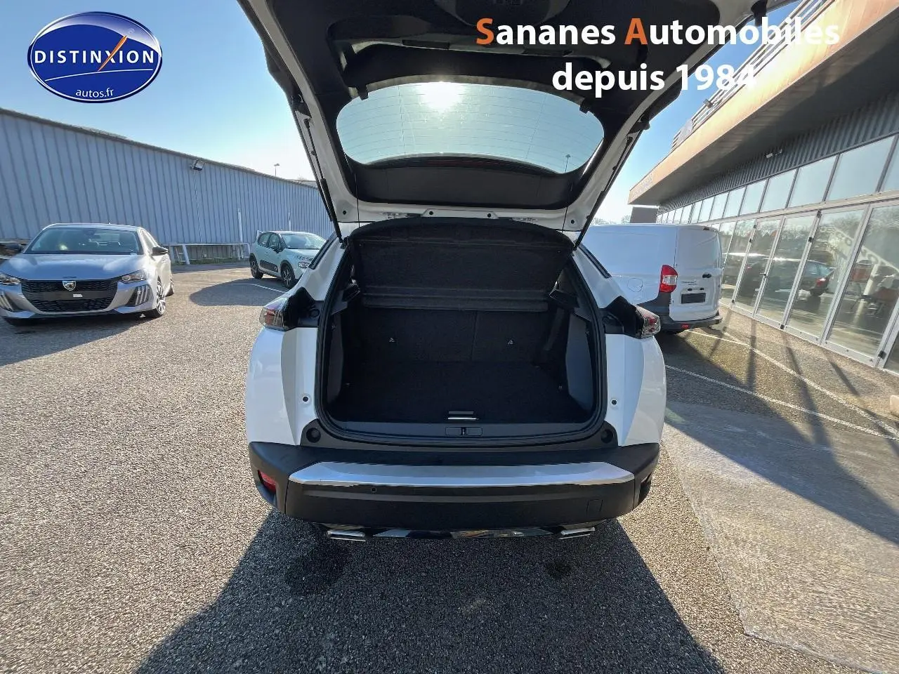Vue arrière d'un Peugeot 2008 blanc 2020 avec coffre ouvert, montrant l'espace de chargement vide.