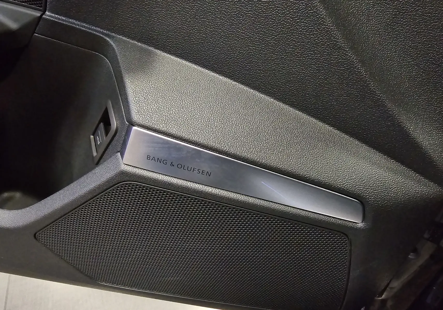 Détail du haut-parleur Bang & Olufsen intégré à la porte intérieure d'une Audi RS3 Sportback noire 2023.