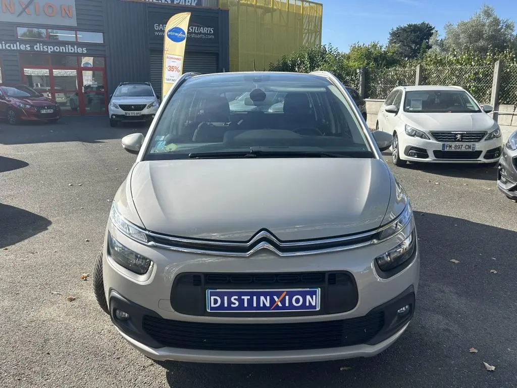 Vue frontale d'un Citroën Grand C4 Spacetourer beige clair 2018 avec calandre distinctive et plaque Distinxion.