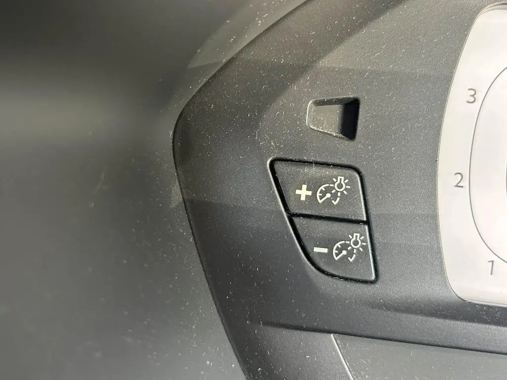 Gros plan sur les boutons de réglage du régulateur de vitesse et des phares du tableau de bord du Citroën Grand C4 Spacetourer beige clair.