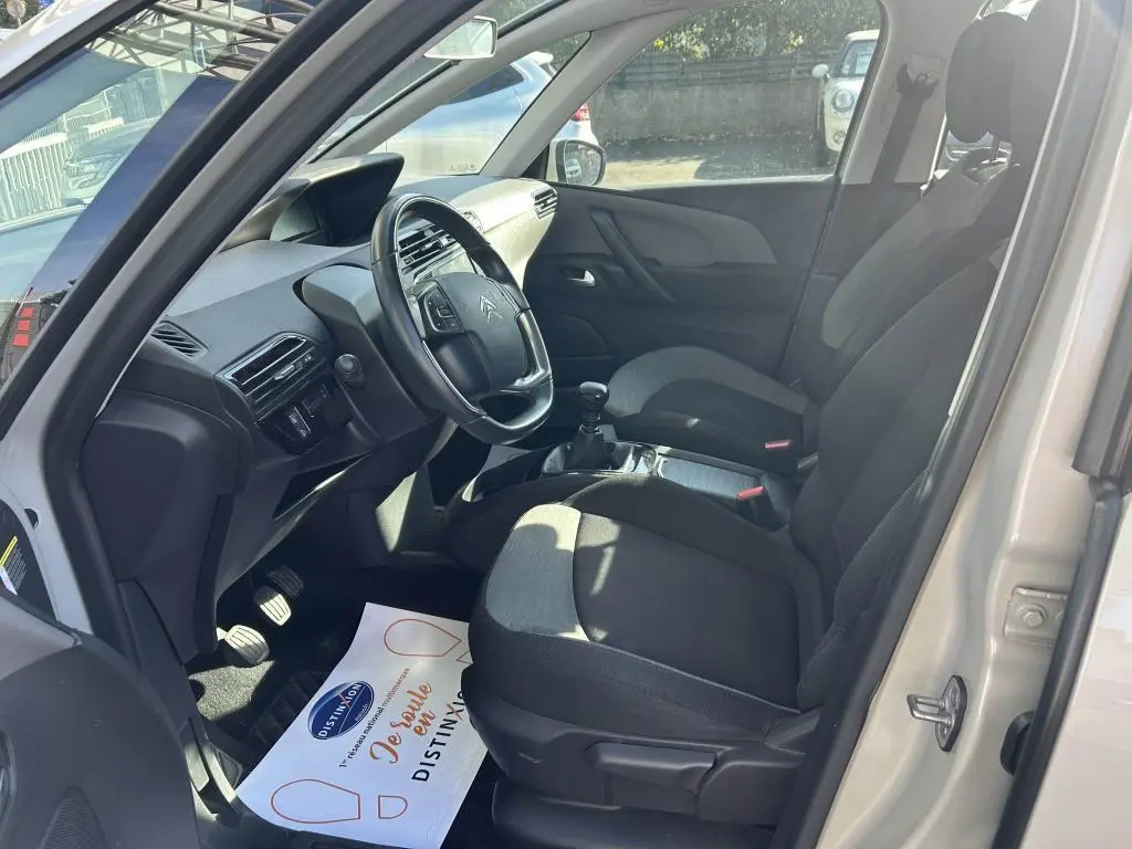 Vue intérieure côté conducteur du Citroën Grand C4 Spacetourer beige clair, montrant sièges et volant avec boîte manuelle.