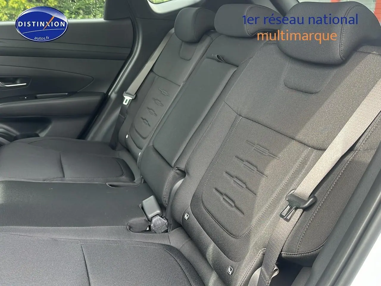 Vue intérieure côté droit sur la banquette arrière noire du Hyundai Tucson 2025 hybride blanc Sérénité.