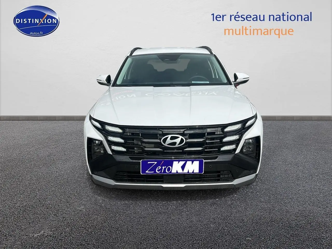 Vue frontale d'un Hyundai Tucson blanc sérénité avec calandre noire et logo Hyundai bien visible