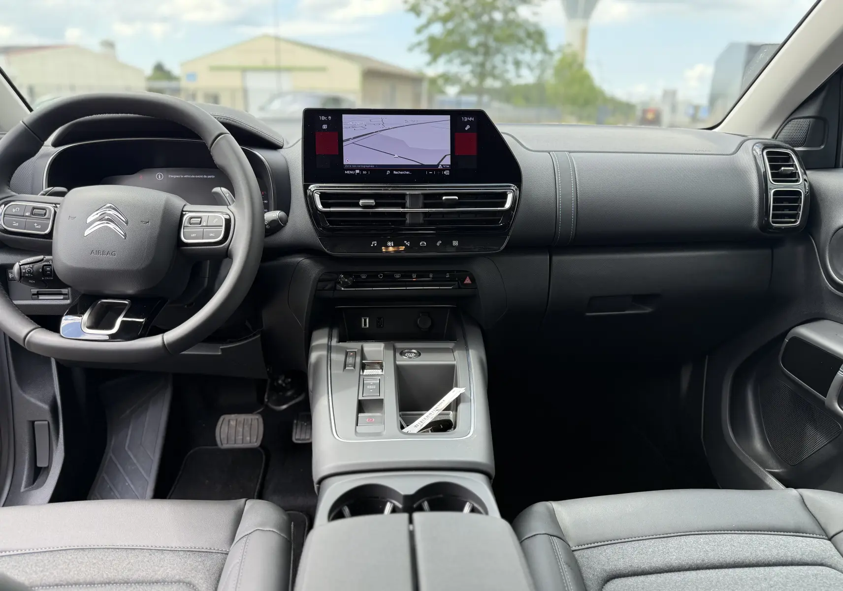 Vue intérieure avant du Citroën C5 Aircross 2025, tableau de bord noir avec écran tactile et volant multifonction.
