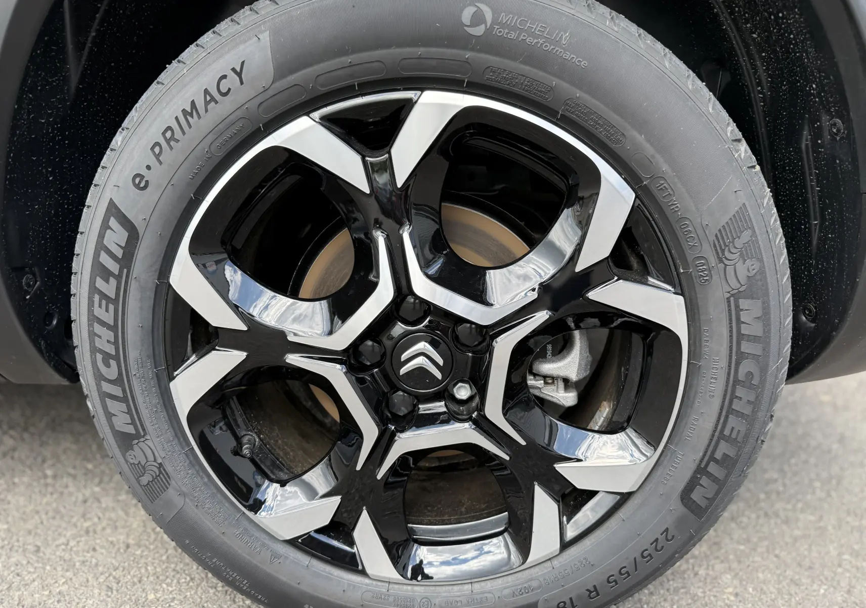 Gros plan sur la jante noire et argentée avec logo Citroën, montée sur pneu Michelin e.PRIMACY, côté droit du C5 Aircross gris.
