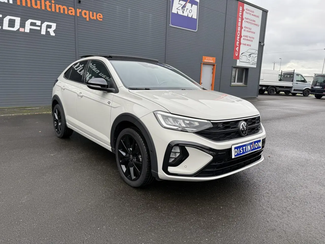 Volkswagen Taigo gris Ascot en 3/4 avant droit avec jantes noires et toit ouvrant en verre visible