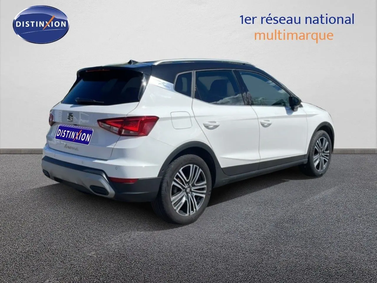 Vue 3/4 arrière droite du SEAT Arona blanc à toit noir, soulignant ses jantes alliage et son design compact.
