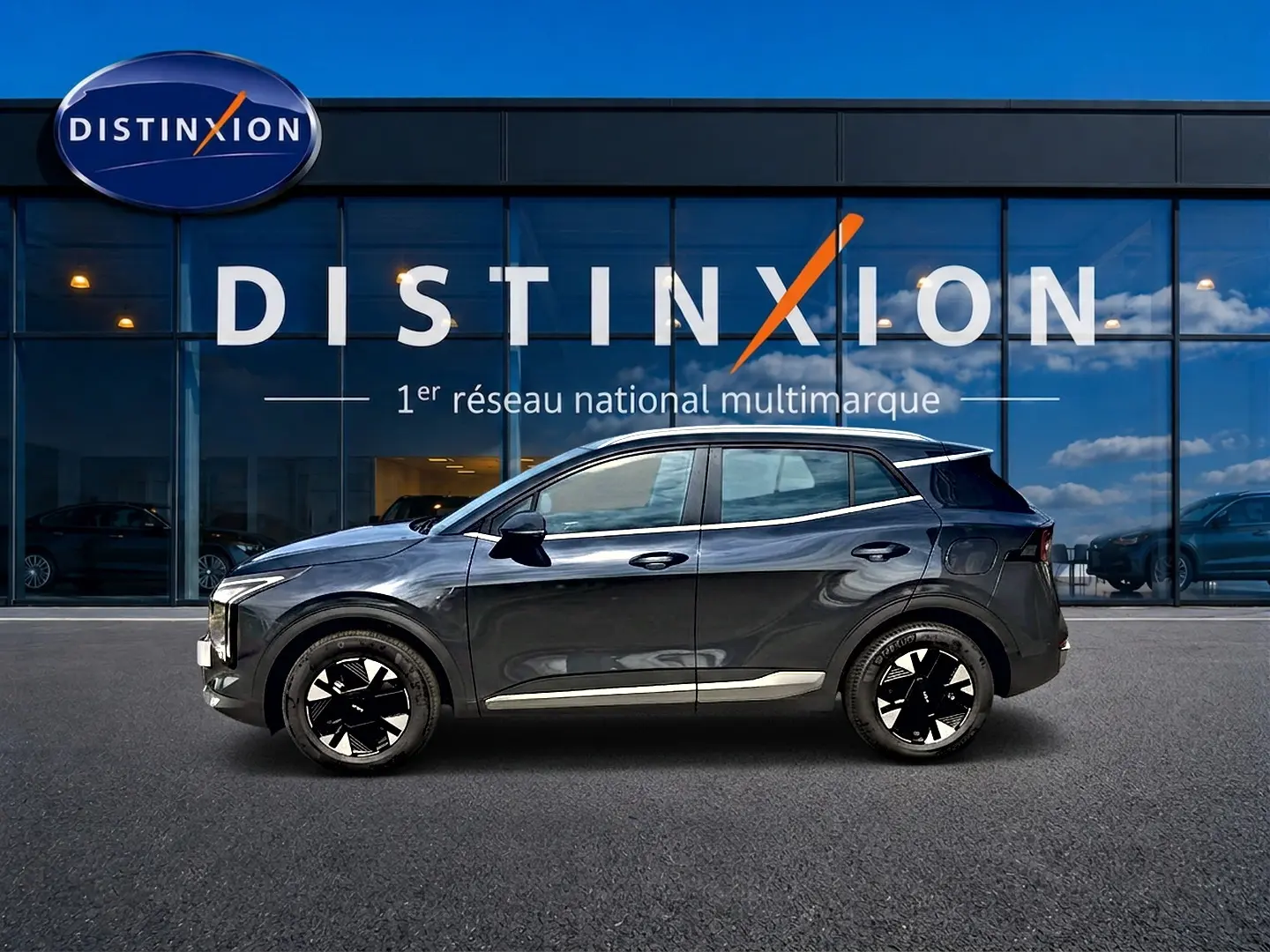 Vue de profil droit du KIA SPORTAGE 1.6 hybride 239 gris eclipse, avec jantes alliage noires et toit noir brillant.
