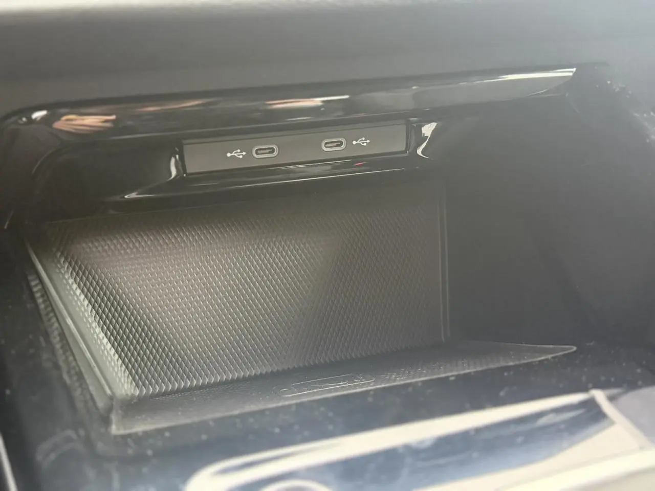 Gros plan sur la console centrale noire de la Volkswagen Golf VIII avec deux ports USB-C intégrés.