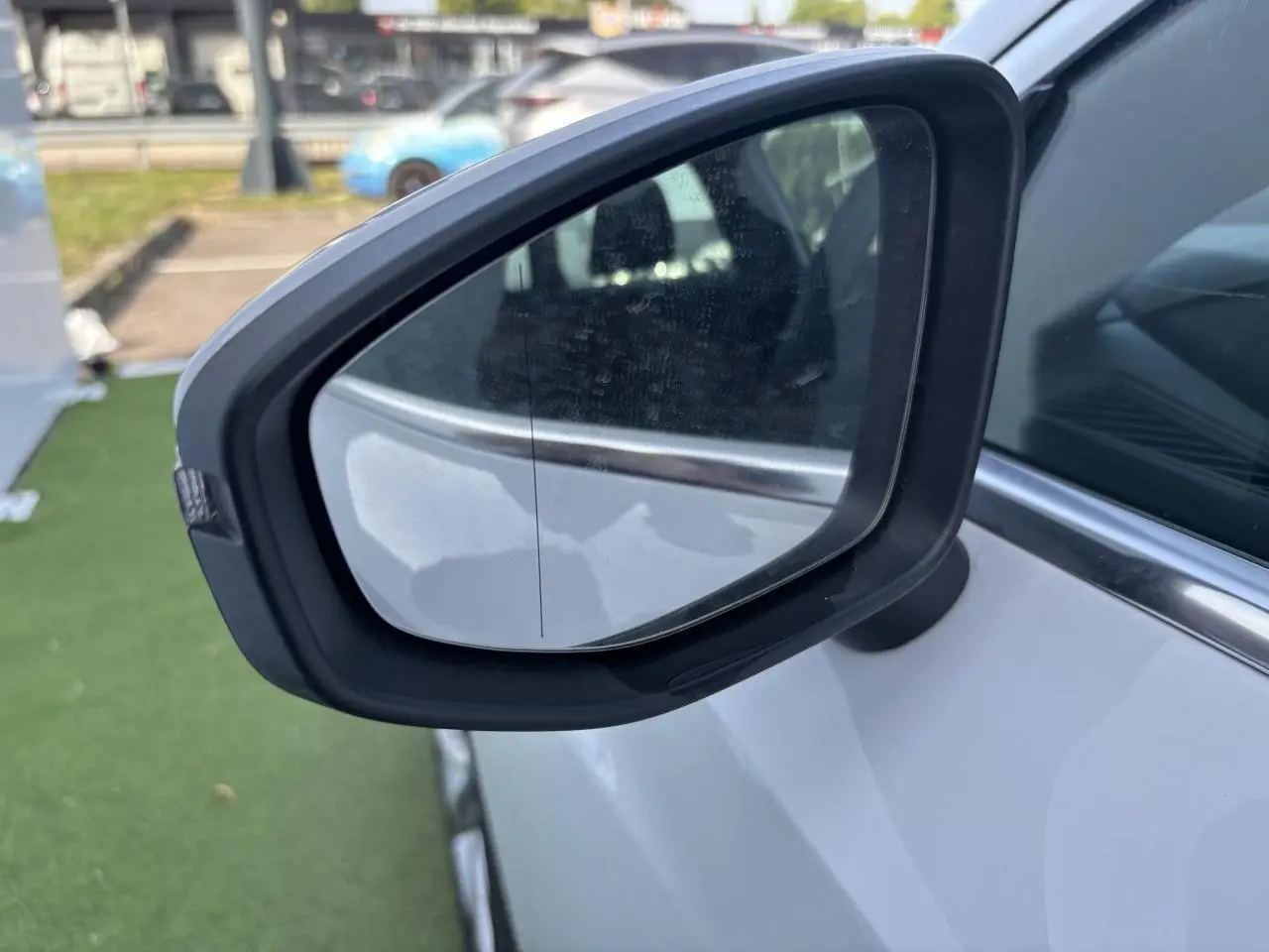 Rétroviseur droit noir sur Audi A3 Sportback blanc Arkona, vue rapprochée côté passager.