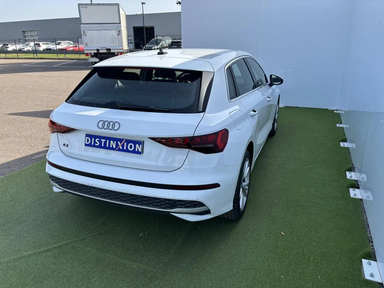 Audi A3 Sportback blanc Arkona vue 3/4 arrière droit, avec feux arrière LED et jantes alliage cinq branches.