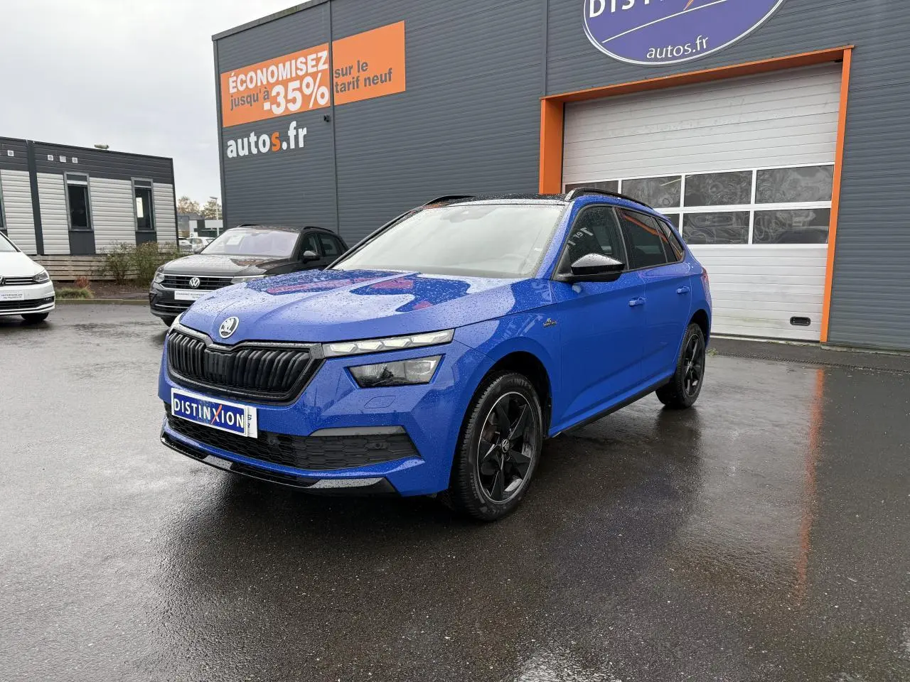 Vue 3/4 avant d'un Skoda Kamiq Monte-Carlo bleu Energy avec jantes alliage noires et calandre noire brillante.