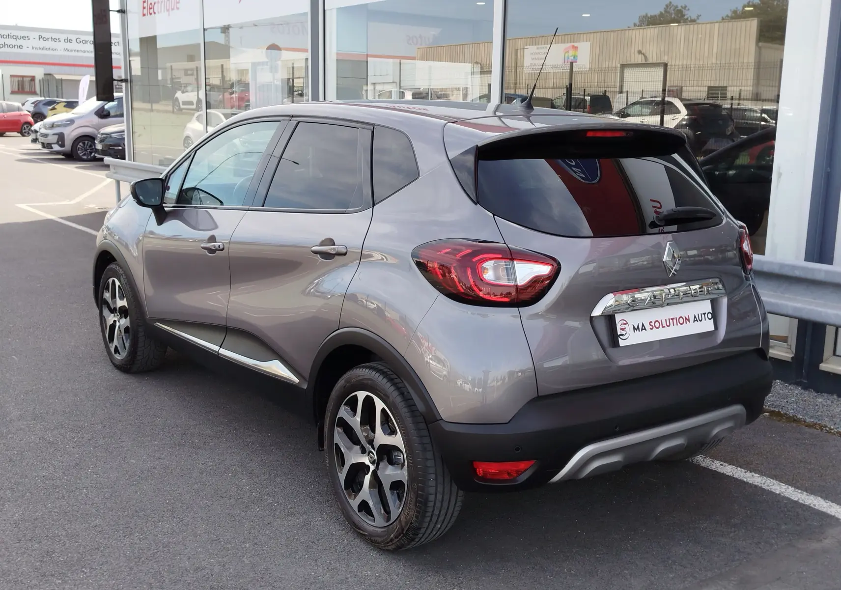 Vue 3/4 arrière droite du Renault Captur gris Cassiopée 2018, avec jantes bi-ton et vitres teintées.