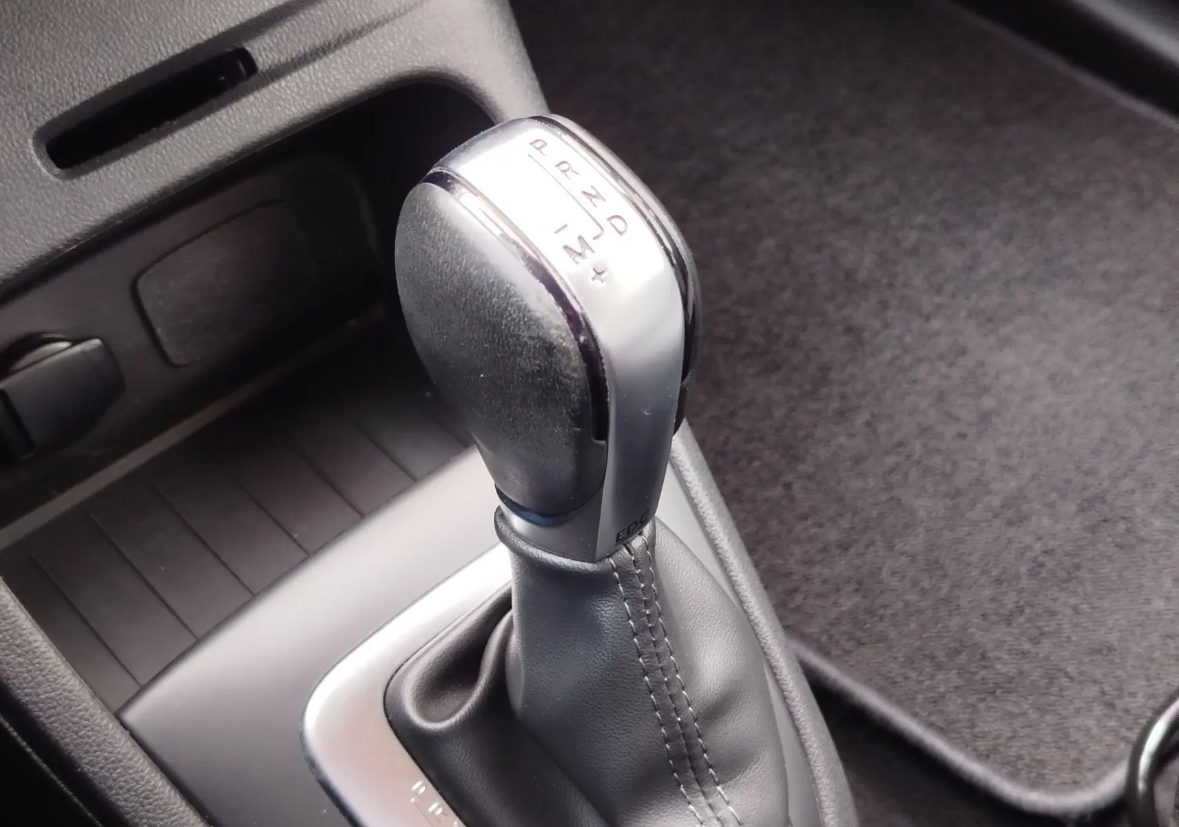 Le levier de vitesse automatique noir et argenté du Renault Captur 1.2 TCe 120ch Intens, vue rapprochée intérieure.