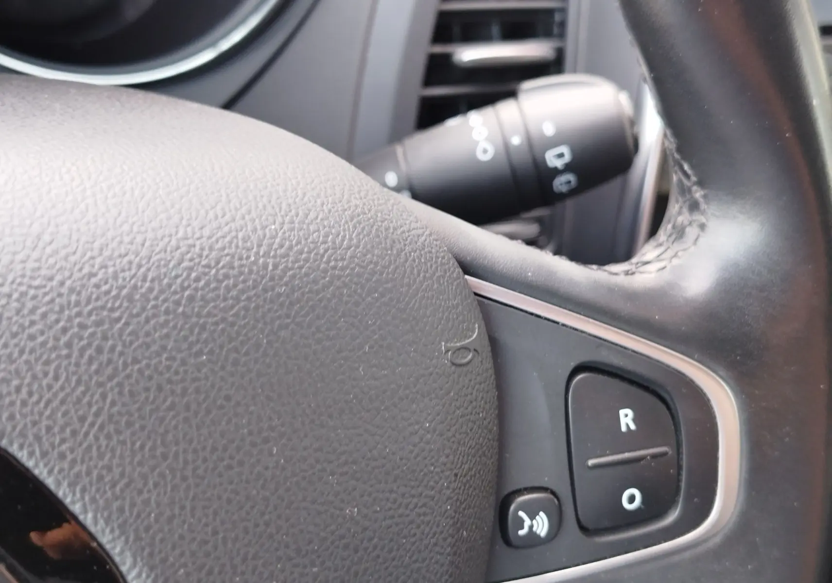 Gros plan sur le volant en cuir noir du Renault Captur 2018, avec commandes vocales et régulateur de vitesse visibles.