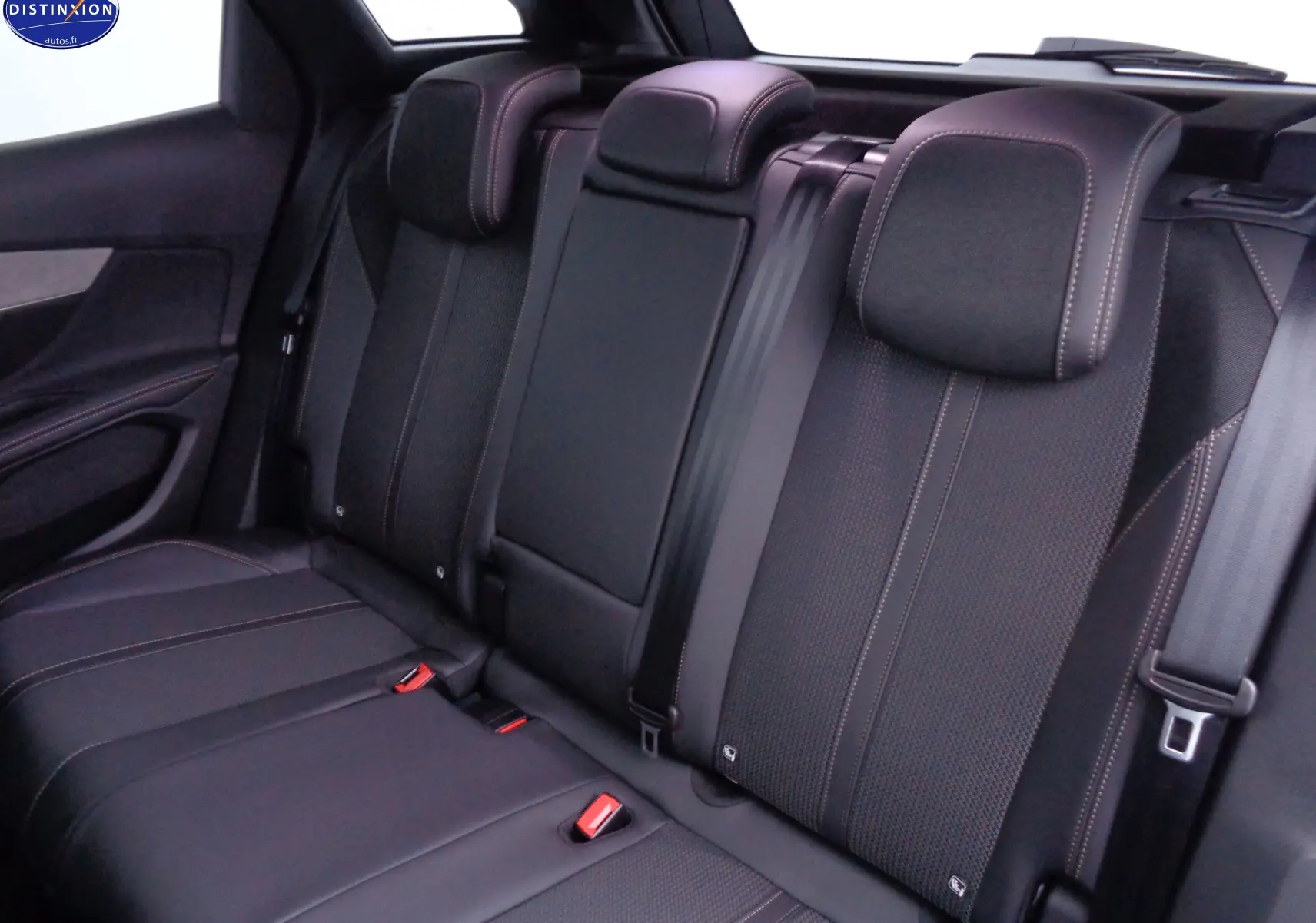 Vue intérieure arrière des sièges noirs en cuir et tissu du Peugeot 3008 GT 2023, soulignant les surpiqûres contrastées.