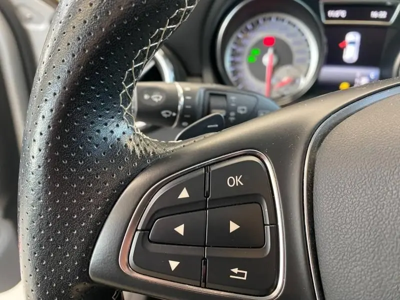 Gros plan sur les commandes au volant côté gauche du Mercedes GLA 200 Sensation 2017 avec tableau de bord en arrière-plan flou.