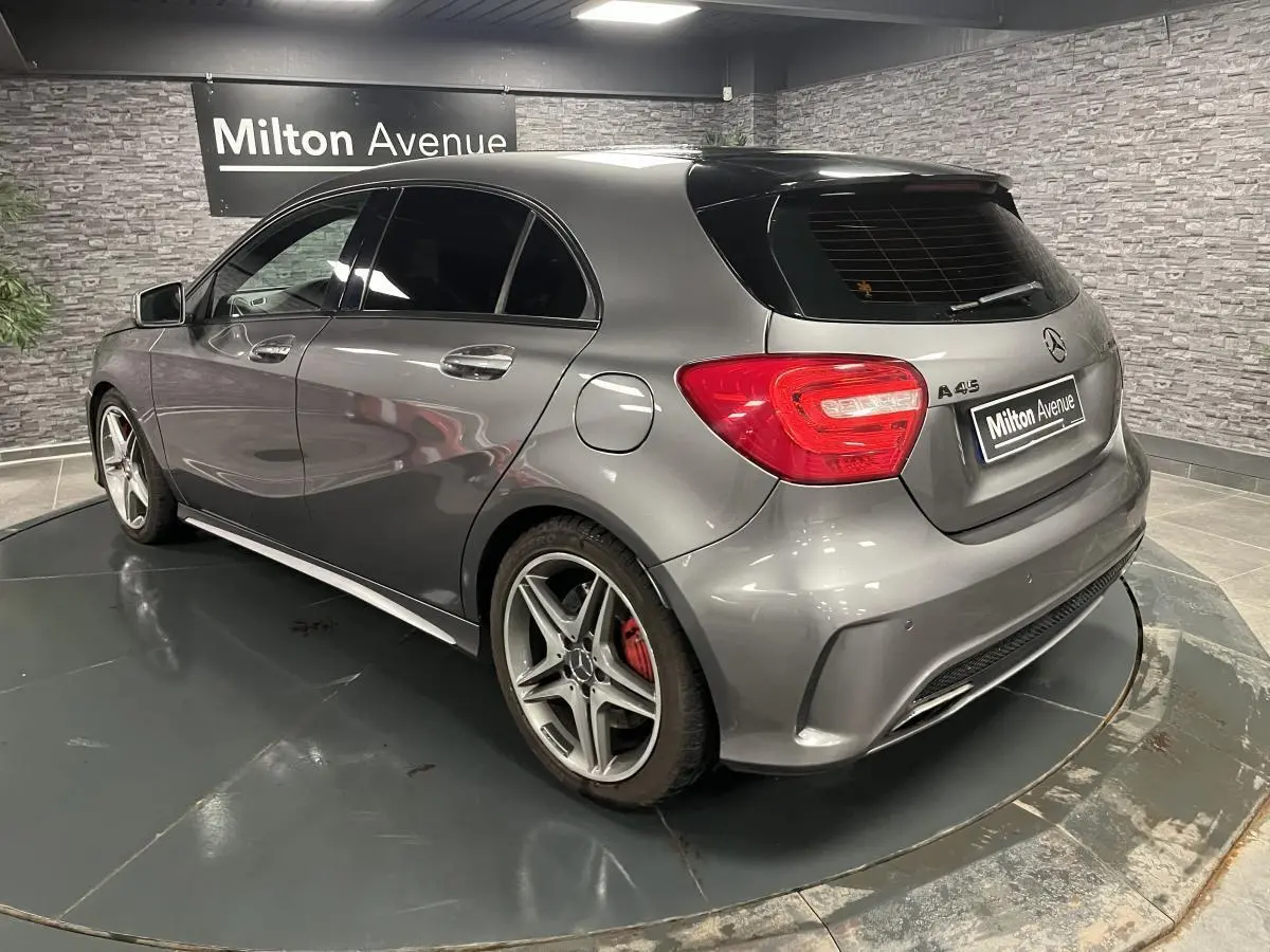 Vue 3/4 arrière droite d'une Mercedes Classe A 45 AMG gris métallisé avec étriers de frein rouges et vitres surteintées.
