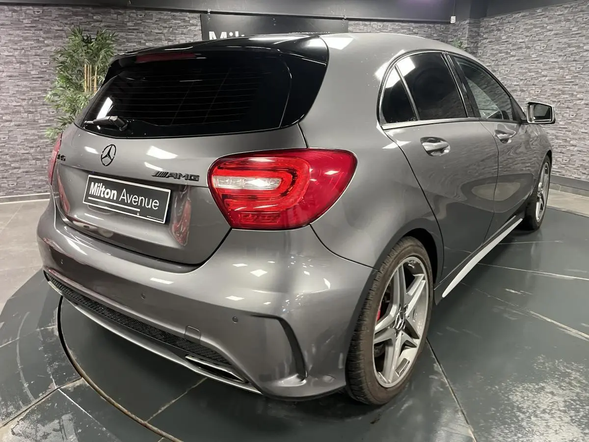Vue 3/4 arrière droite d'une Mercedes Classe A 45 AMG grise avec jantes AMG et étriers de frein rouges visibles.