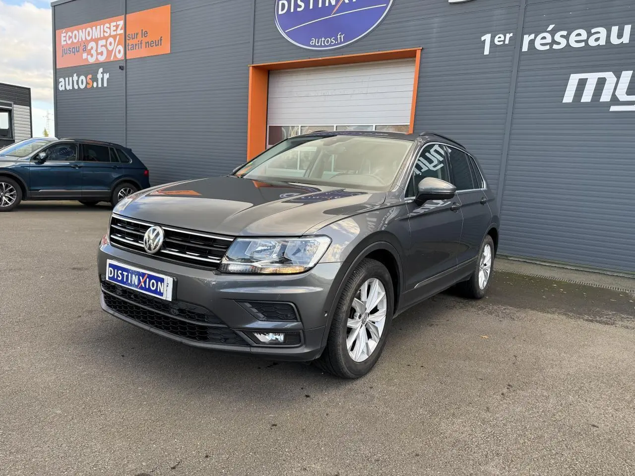 Volkswagen Tiguan gris Indium vu en 3/4 avant droit avec jantes alliage et projecteurs antibrouillard.