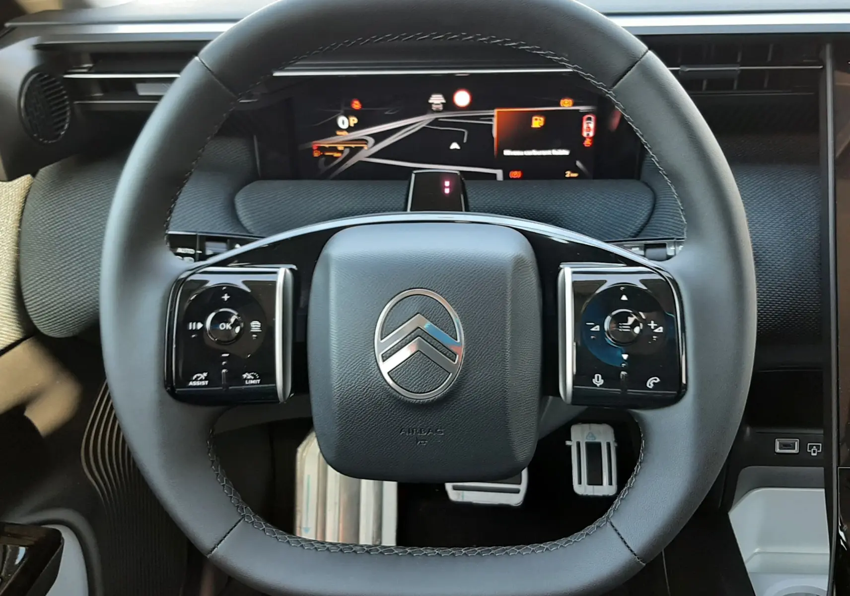 Vue rapprochée du volant noir du Citroën C5 Aircross 2026 avec tableau de bord numérique et commandes intégrées.