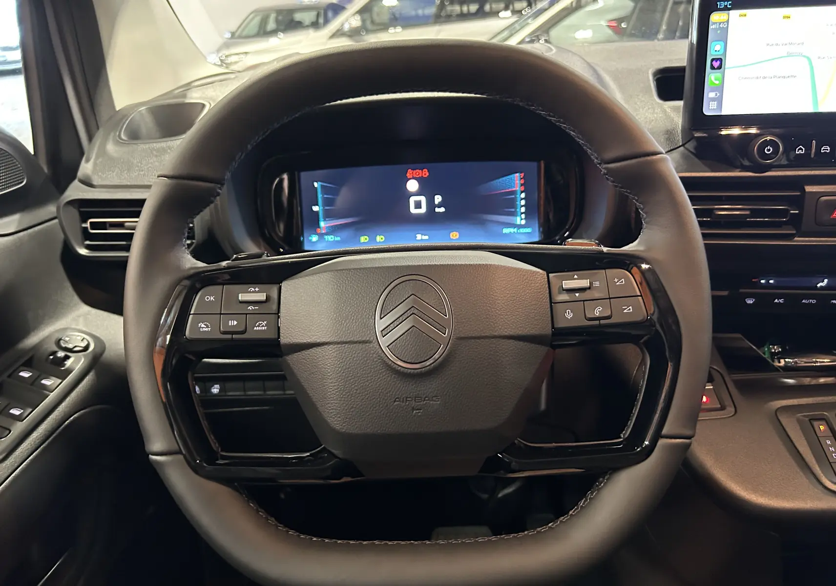 Vue rapprochée du volant multifonction noir du Citroën Berlingo Multispace 2025 avec tableau de bord numérique et écran tactile.