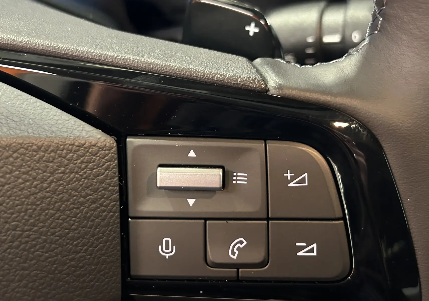 Gros plan sur les commandes au volant du Citroën Berlingo Multispace gris, avec boutons de volume et téléphone.