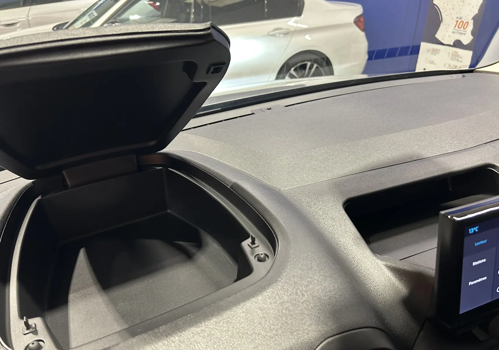 Coffre de rangement ouvert sur le tableau de bord du Citroën Berlingo Multispace 2025, intérieur noir mat.