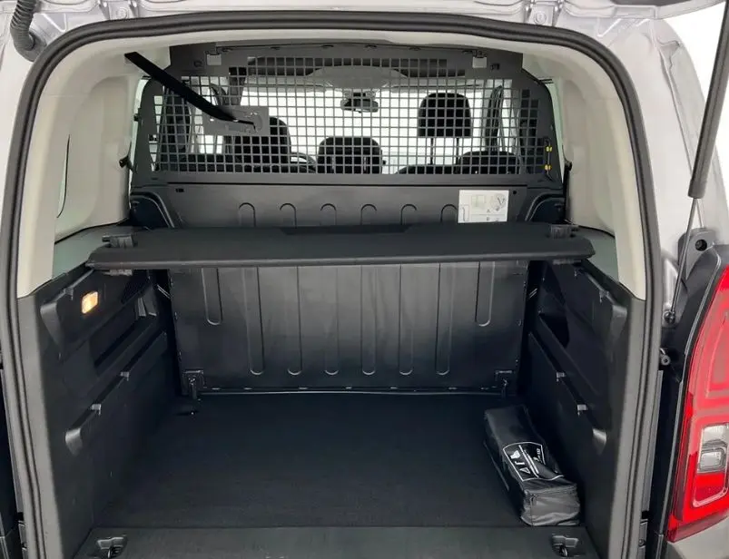 Coffre ouvert d’un Citroën Berlingo Multispace gris Artense, montrant la cloison de séparation et l’espace de chargement vide.
