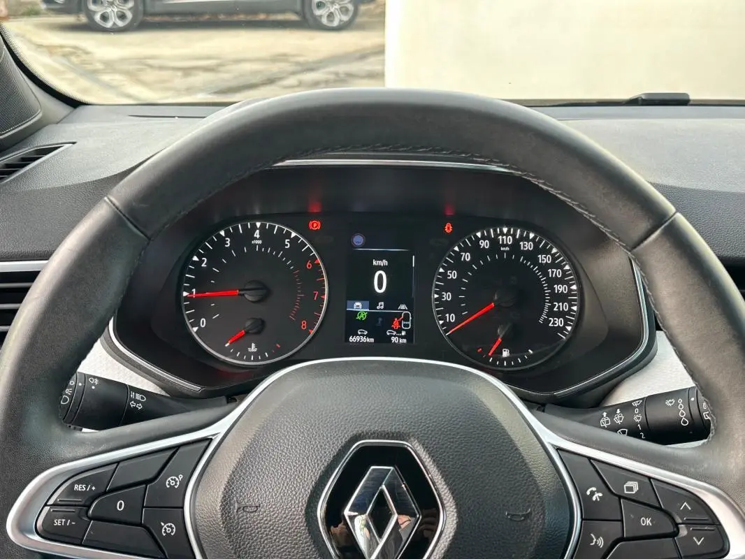 Vue intérieure du tableau de bord et volant de la Renault Clio V SCe 65 noir, avec affichage numérique et commandes au volant.