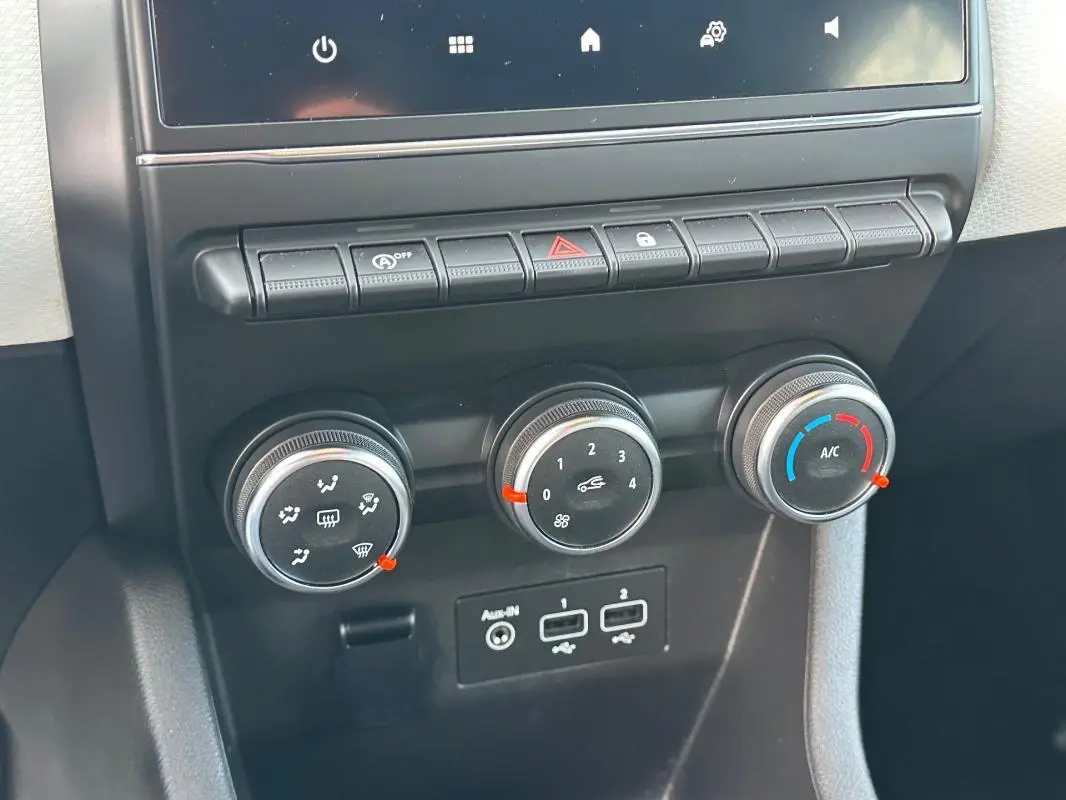 Gros plan sur les commandes de climatisation manuelle et les ports USB de la Renault Clio V SCe 65 Limited noire de 2021.