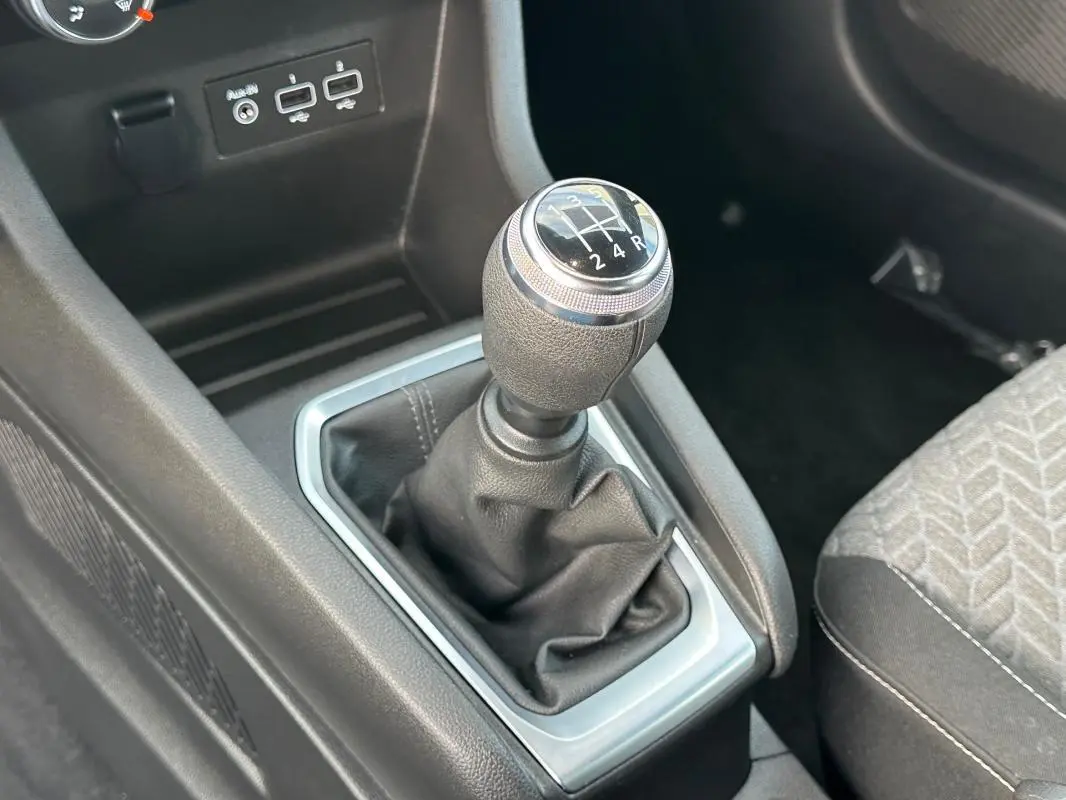 Le levier de vitesse manuel de la Renault Clio V SCe 65 21 Limited, entouré de garnitures noires et argentées.