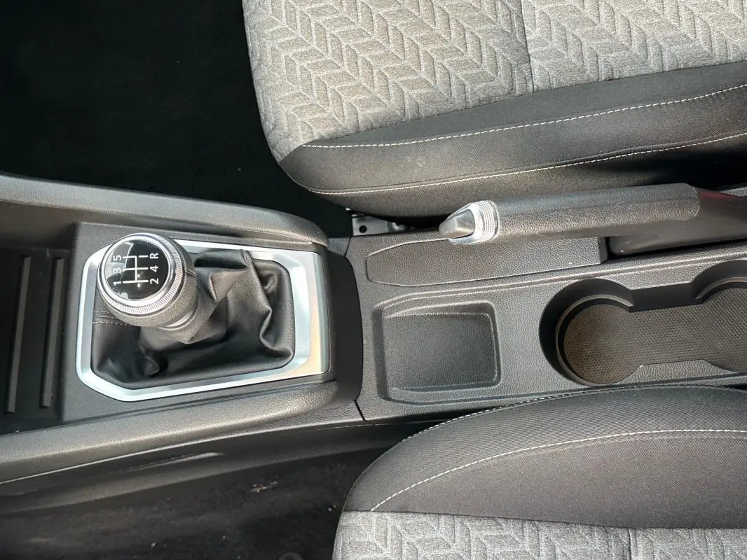 Vue rapprochée de la console centrale de la Renault Clio noire 2021, avec levier de vitesse manuel et frein à main.