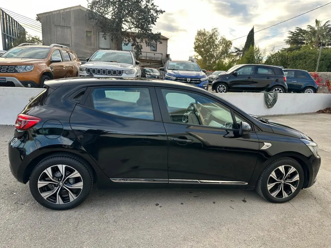 Profil côté gauche d'une Renault Clio V noire de 2021 avec jantes alliage 16 pouces, garée en extérieur.