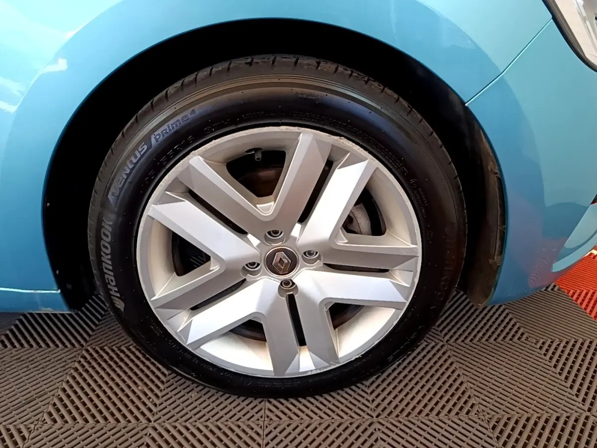 Gros plan sur la roue avant droite d’une Renault Clio Business E-Tech hybride 2021 bleu avec jante alliage distinctive.