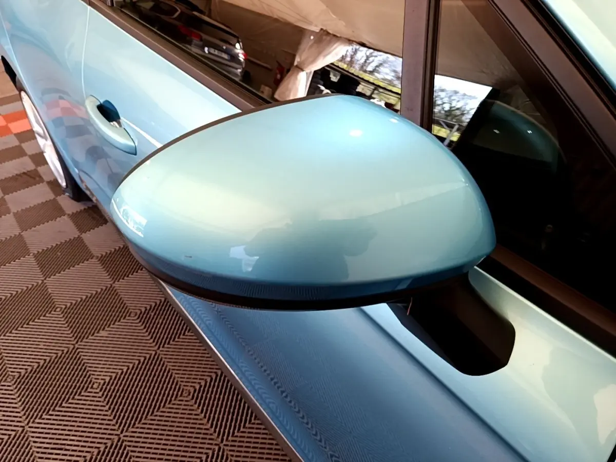 Gros plan sur le rétroviseur côté conducteur bleu clair d'une Renault Clio Business E-Tech hybride 2021, avec poignée de porte visible.