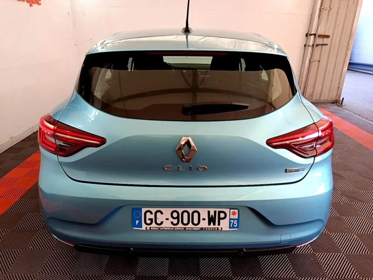 Vue arrière d'une Renault Clio Business E-Tech hybride bleu clair avec feux arrière LED et plaque d'immatriculation française.