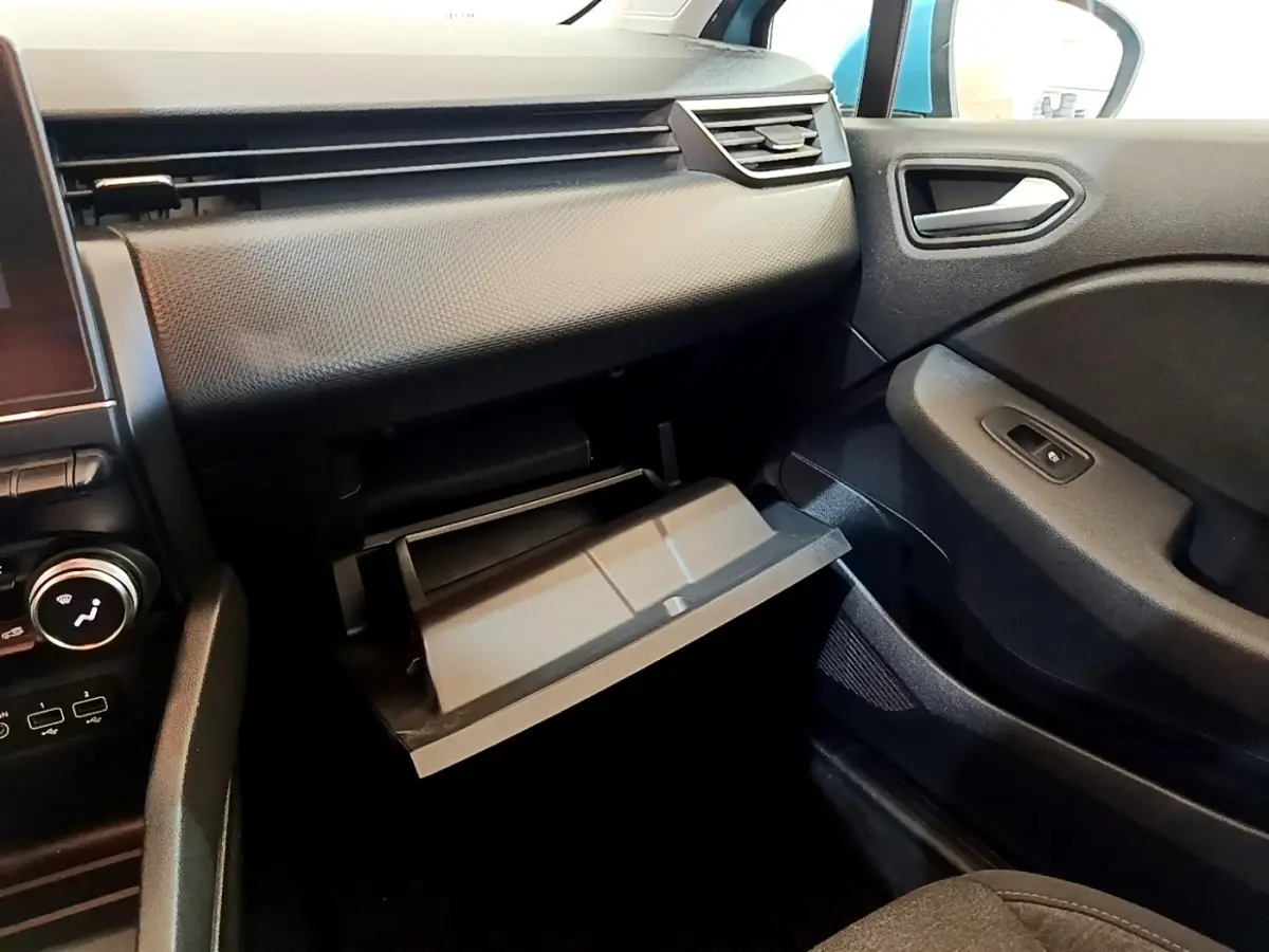 Intérieur côté passager de la Renault Clio Business E-Tech 2021, boîte à gants ouverte, tableau de bord noir texturé.