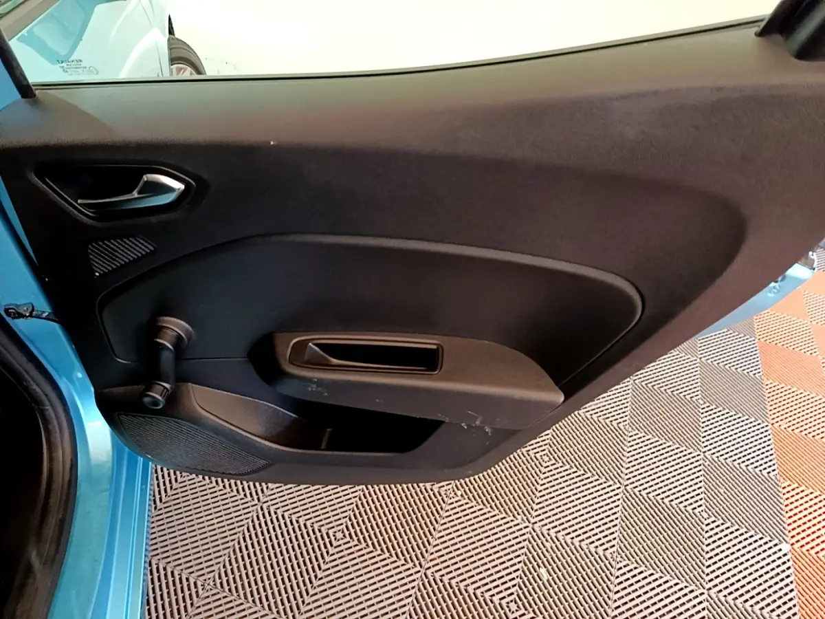 Vue intérieure de la porte avant gauche d'une Renault Clio Business E-Tech hybride bleu, avec poignée et manivelle de vitre.