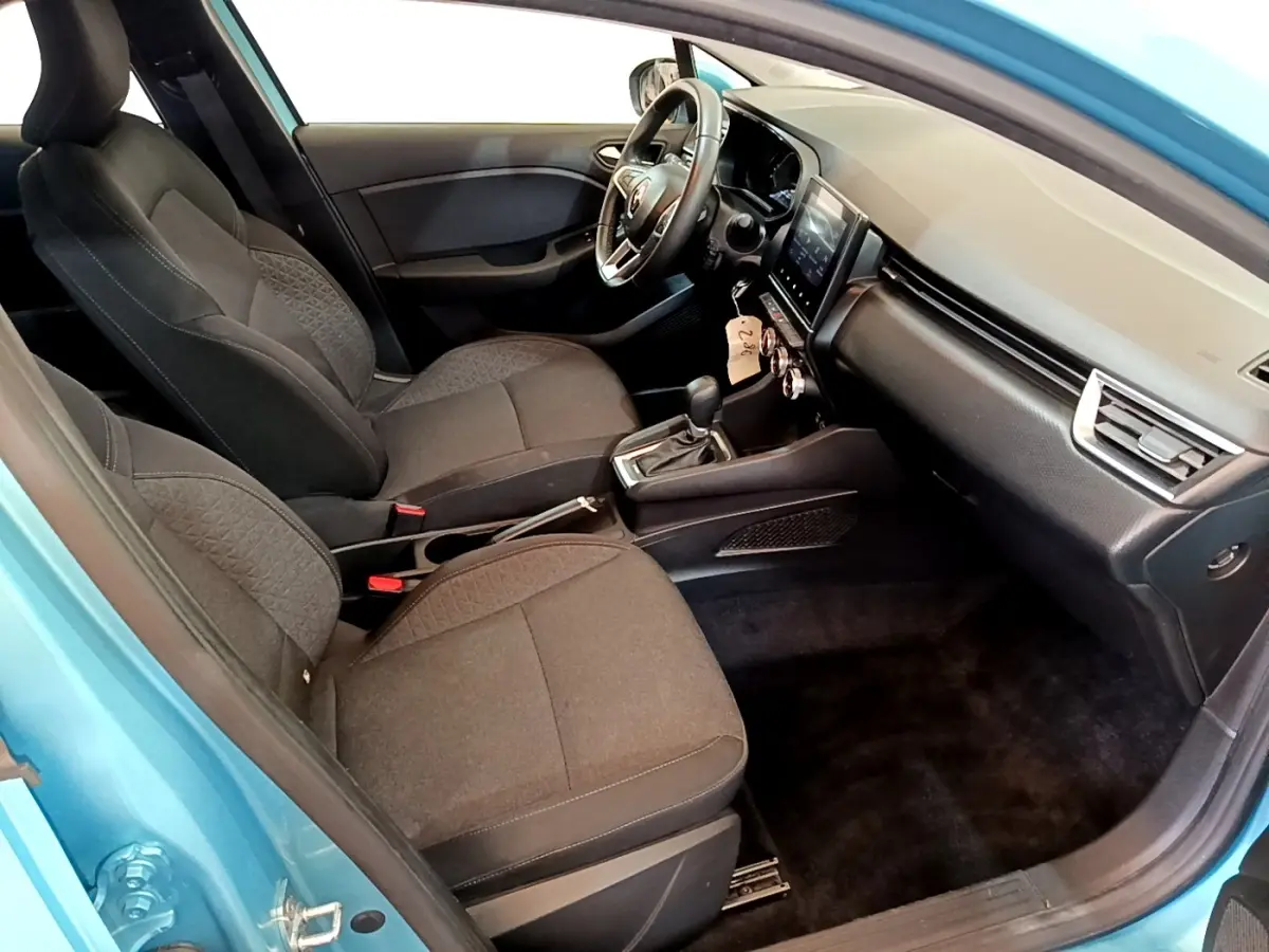 Vue intérieure côté conducteur de la Renault Clio Business E-Tech hybride 2021 bleu, sièges noirs et tableau de bord moderne.
