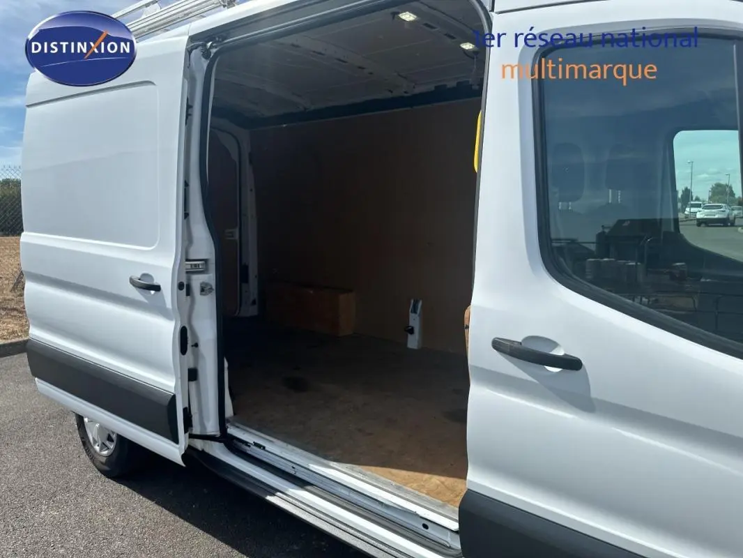 Vue latérale gauche d’un Ford Transit Fourgon blanc 2015 avec porte coulissante ouverte montrant l’espace de chargement.