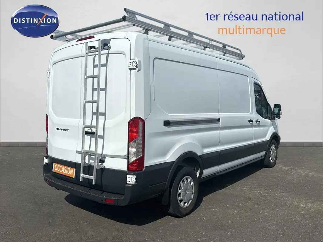 Vue 3/4 arrière droite d’un Ford Transit blanc avec échelle et galerie de toit, sur fond neutre.