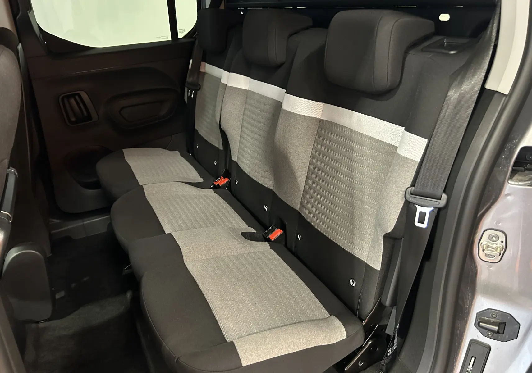Banquette arrière en tissu gris et noir vue côté droit du Citroën Berlingo Multispace gris Artense avec porte ouverte.