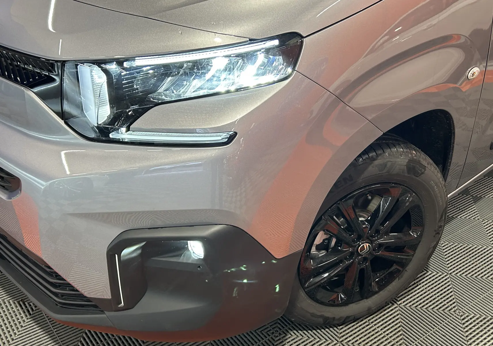 Gros plan sur l'avant droit gris Artense du Citroën Berlingo Multispace avec phare LED et jante noire brillante.