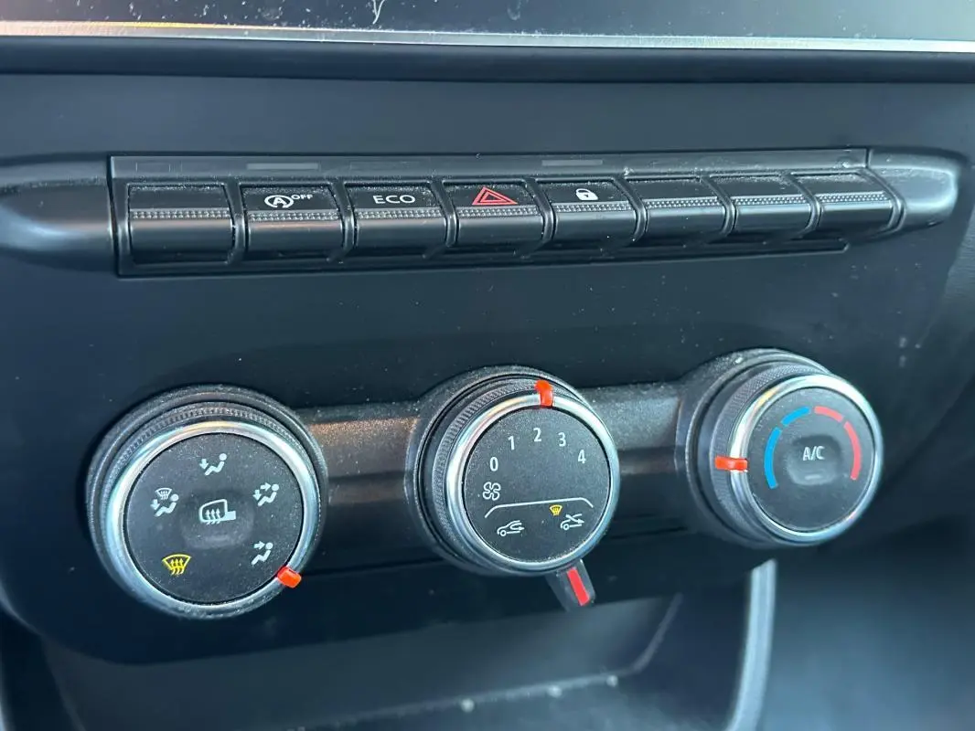 Gros plan sur les commandes de climatisation et boutons fonctionnels du tableau de bord du Renault Express Van blanc 2023.