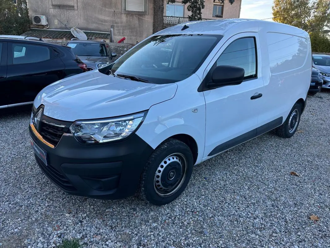 Renault Express Van blanc vu en 3/4 avant droit, avec pare-chocs noir et jantes acier simples sur un sol gravillonné.